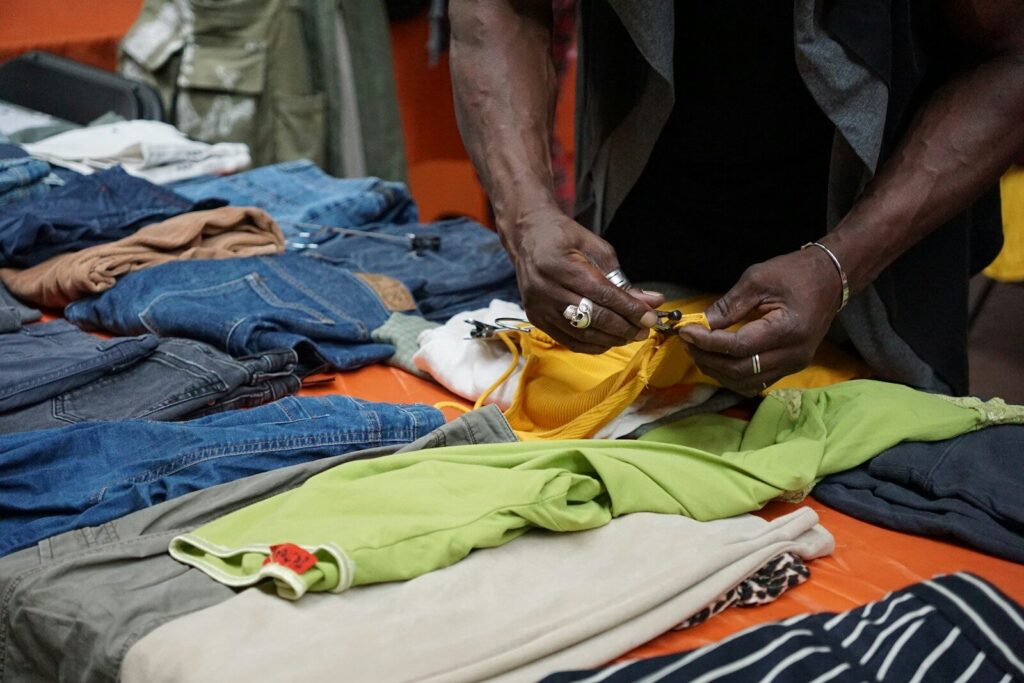 A person folds clothes on a table.
